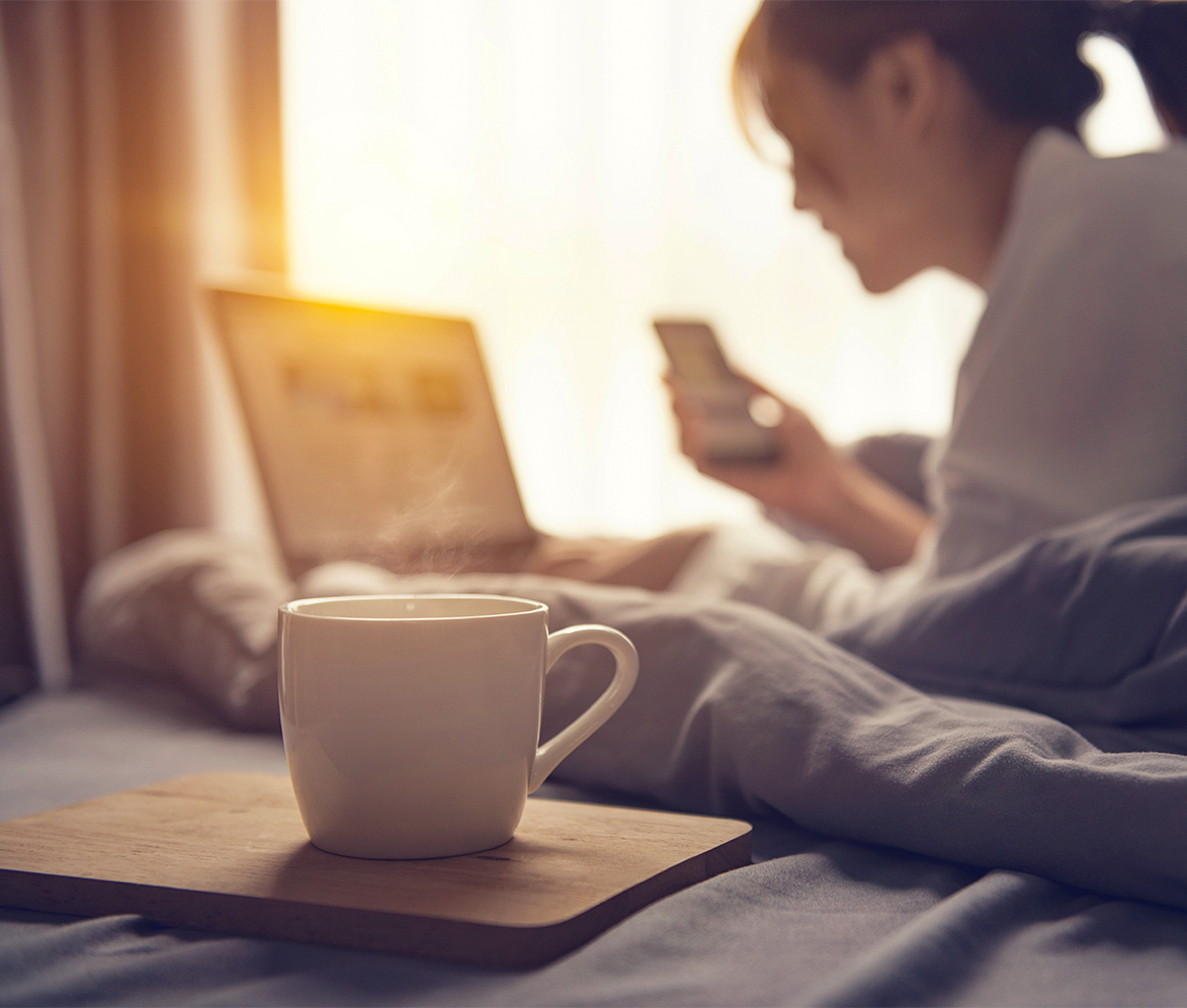 a cup of coffee on a tray next to a woman