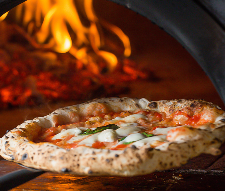 a pizza being cooked in a wood oven