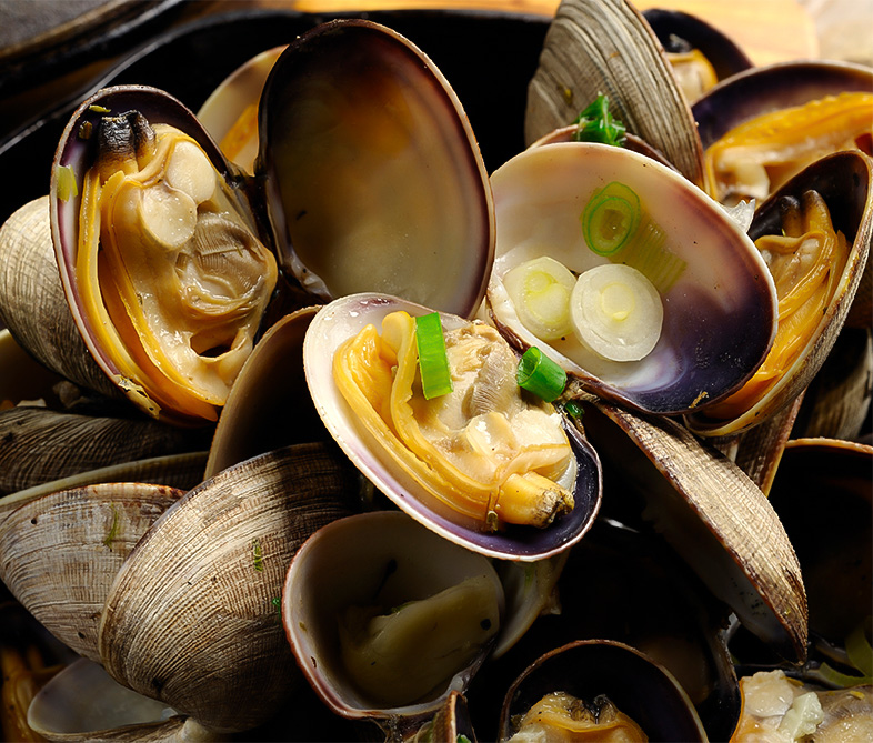 a bowl of clams with onions and sauce