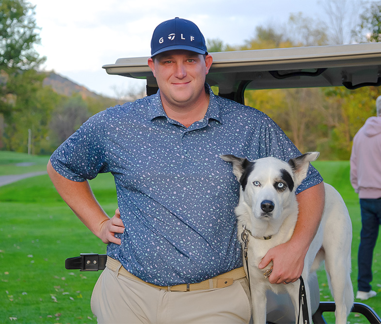 a man standing next to a dog
