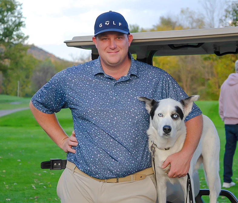 a man standing next to a dog