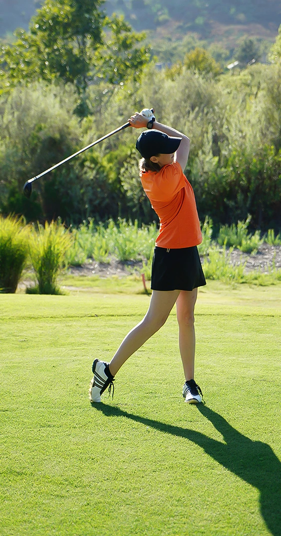 a woman swinging a golf club