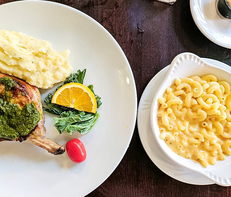 a plate of food next to a bowl of macaroni and cheese
