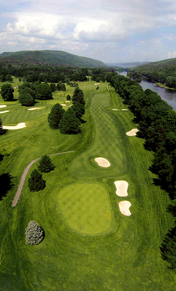 a golf course with a river and trees