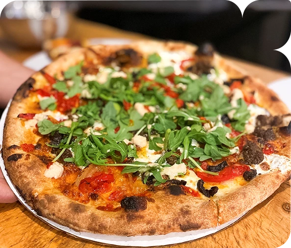 a pizza with toppings on a wooden surface
