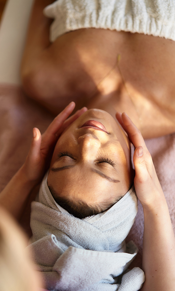 a woman lying down with her hands on her face