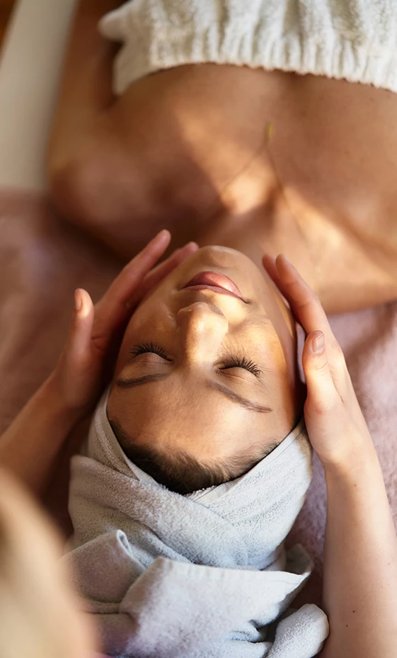 a woman lying down with her hands on her face