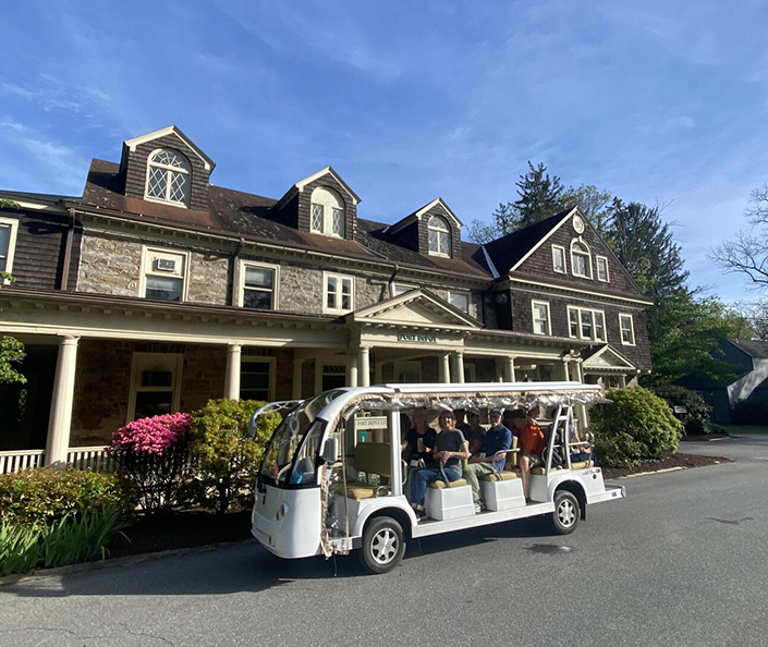 a group of people on a white vehicle in front of a house