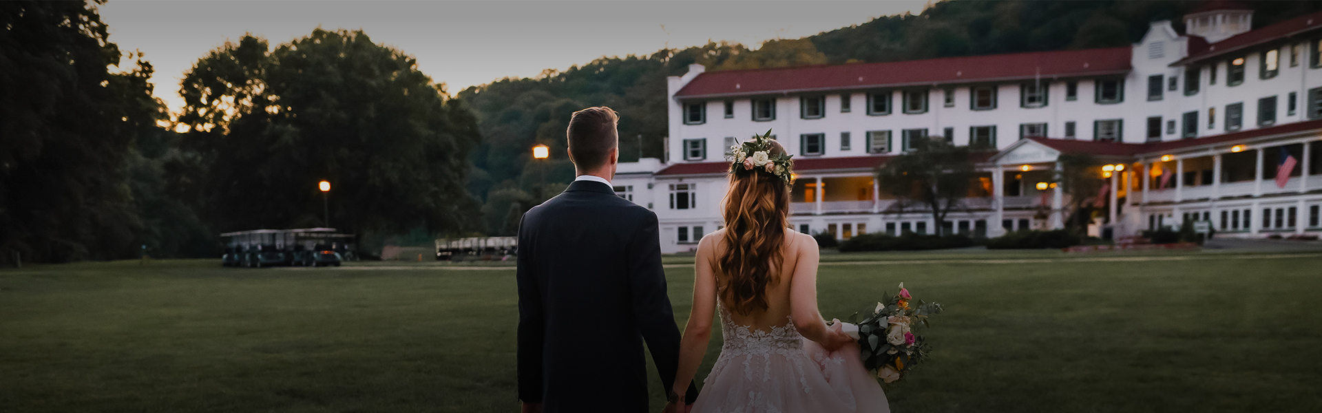 a man and woman holding hands and walking in front of a white house