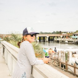 a woman on a balcony drinking a beer