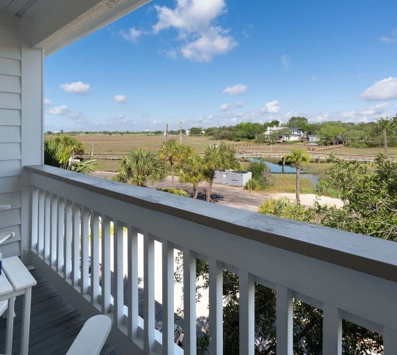 a balcony with a view of a field and trees