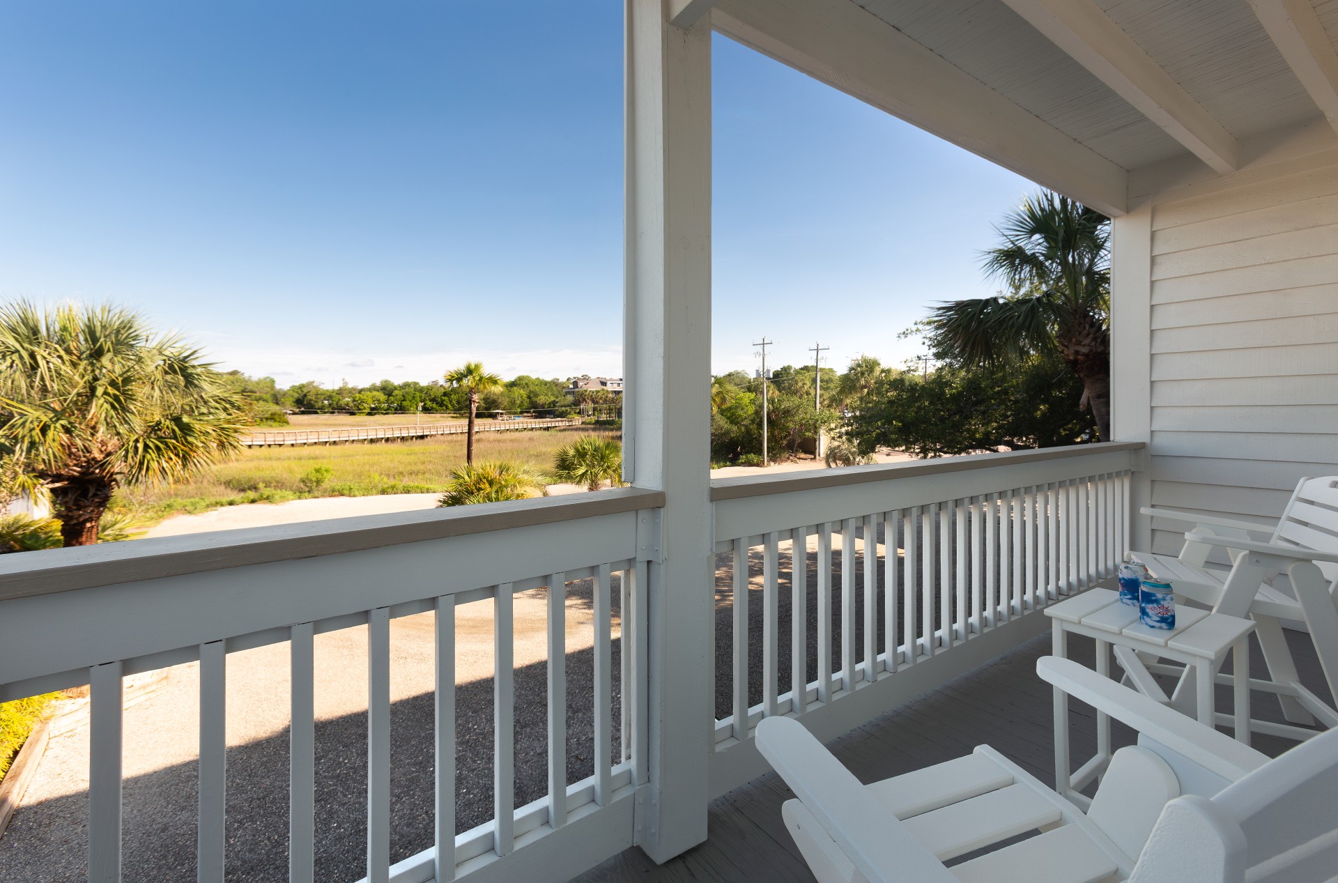 a white deck with chairs and a table and a fence