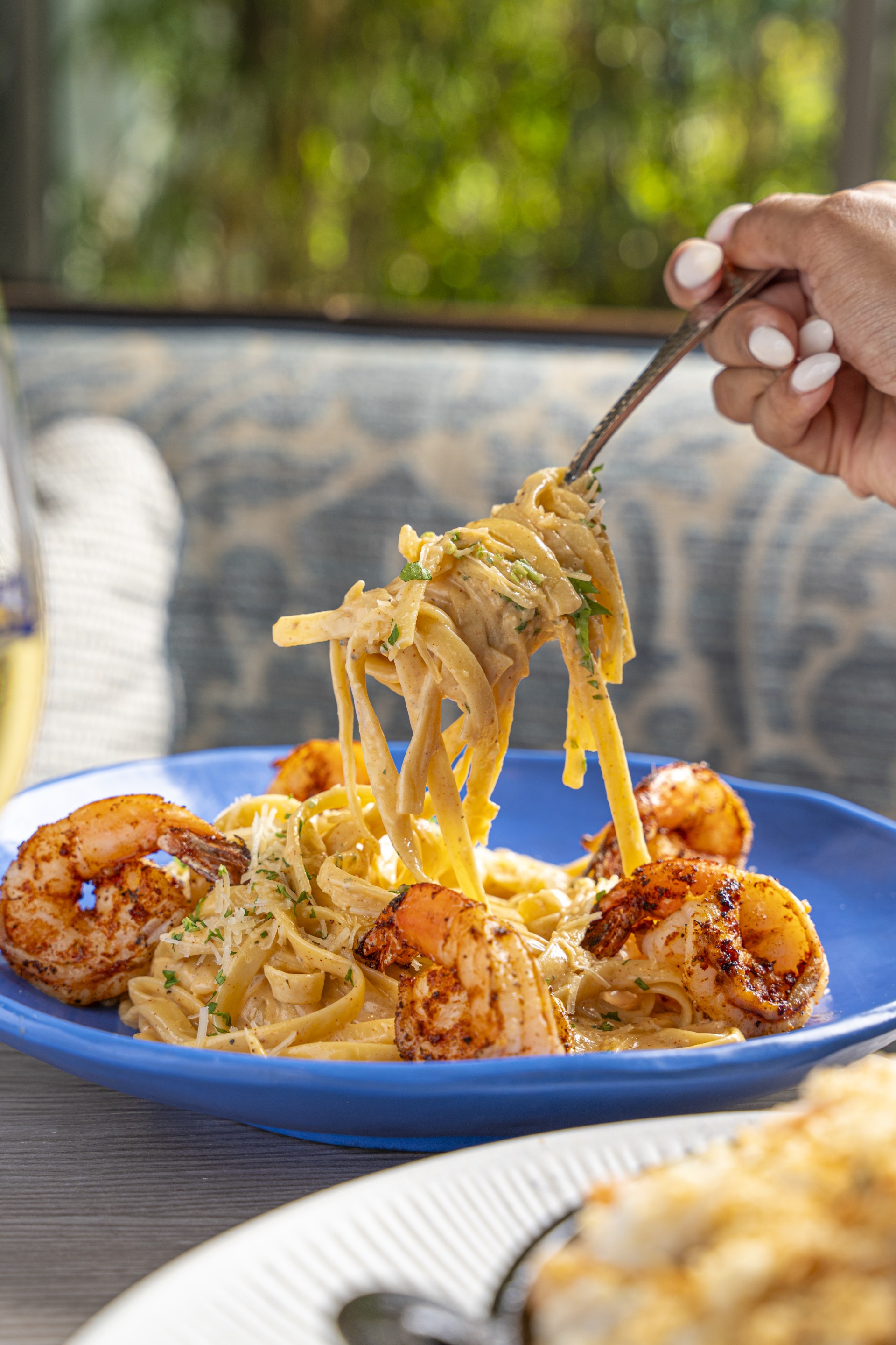 a person holding a fork over a plate of pasta