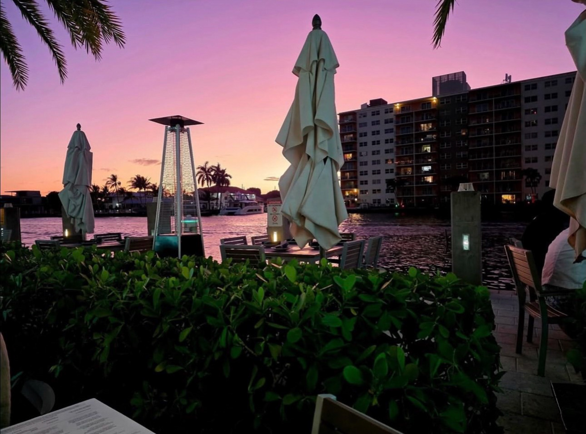 a group of tables and chairs next to a body of water