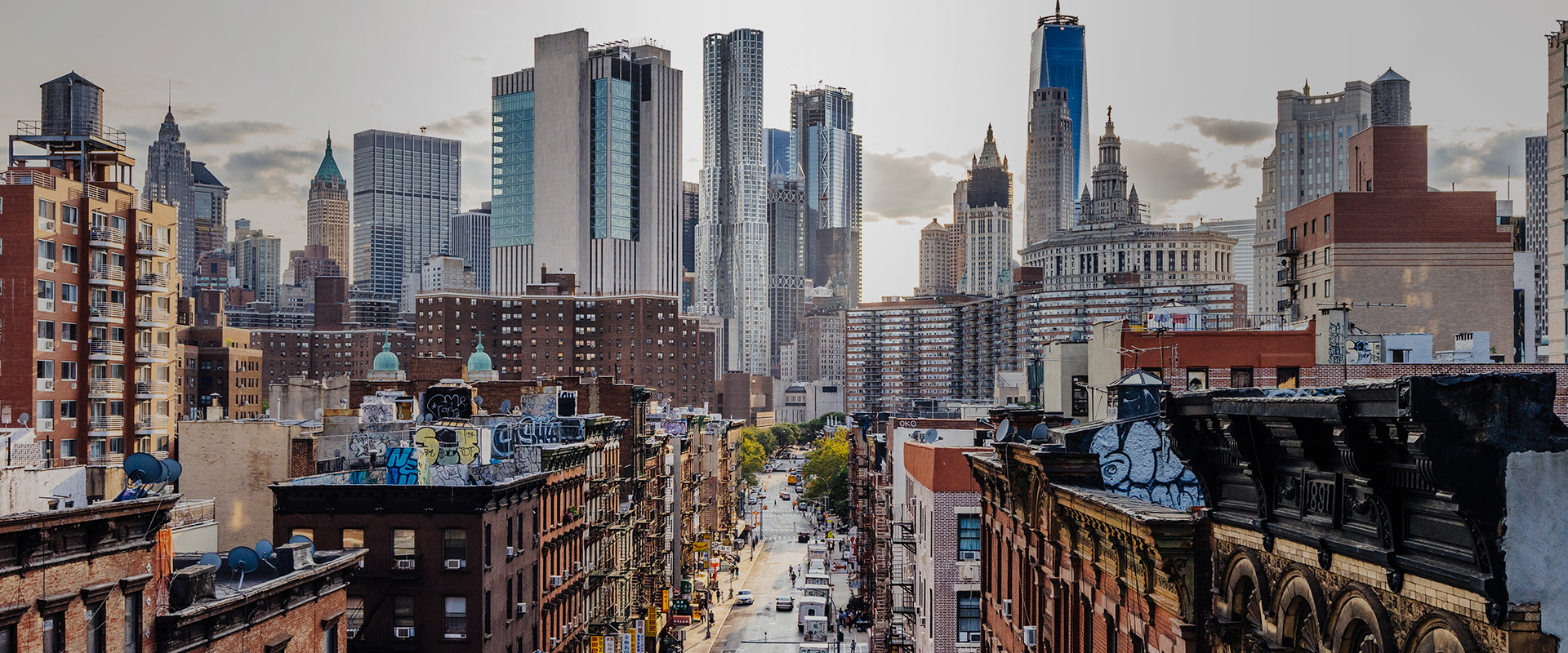 A city street with tall buildings and skyscrapers in the background.