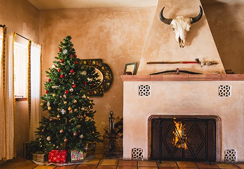 a christmas tree in a lobby with a fireplace