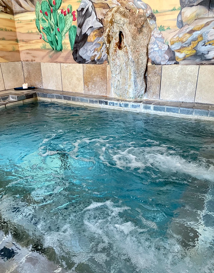 a pool with water and a rock wall