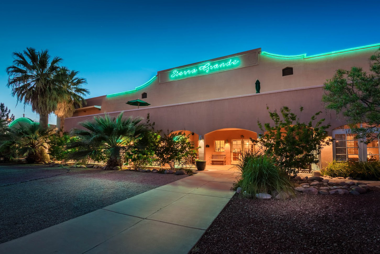 a building with palm trees and a walkway