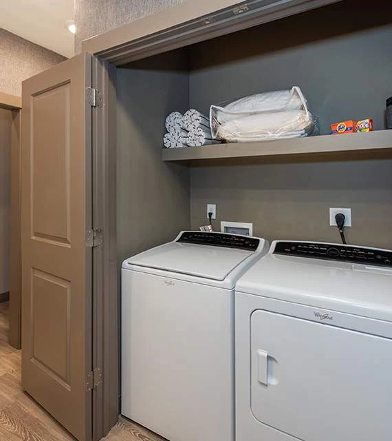 a laundry room with a shelf and a dryer