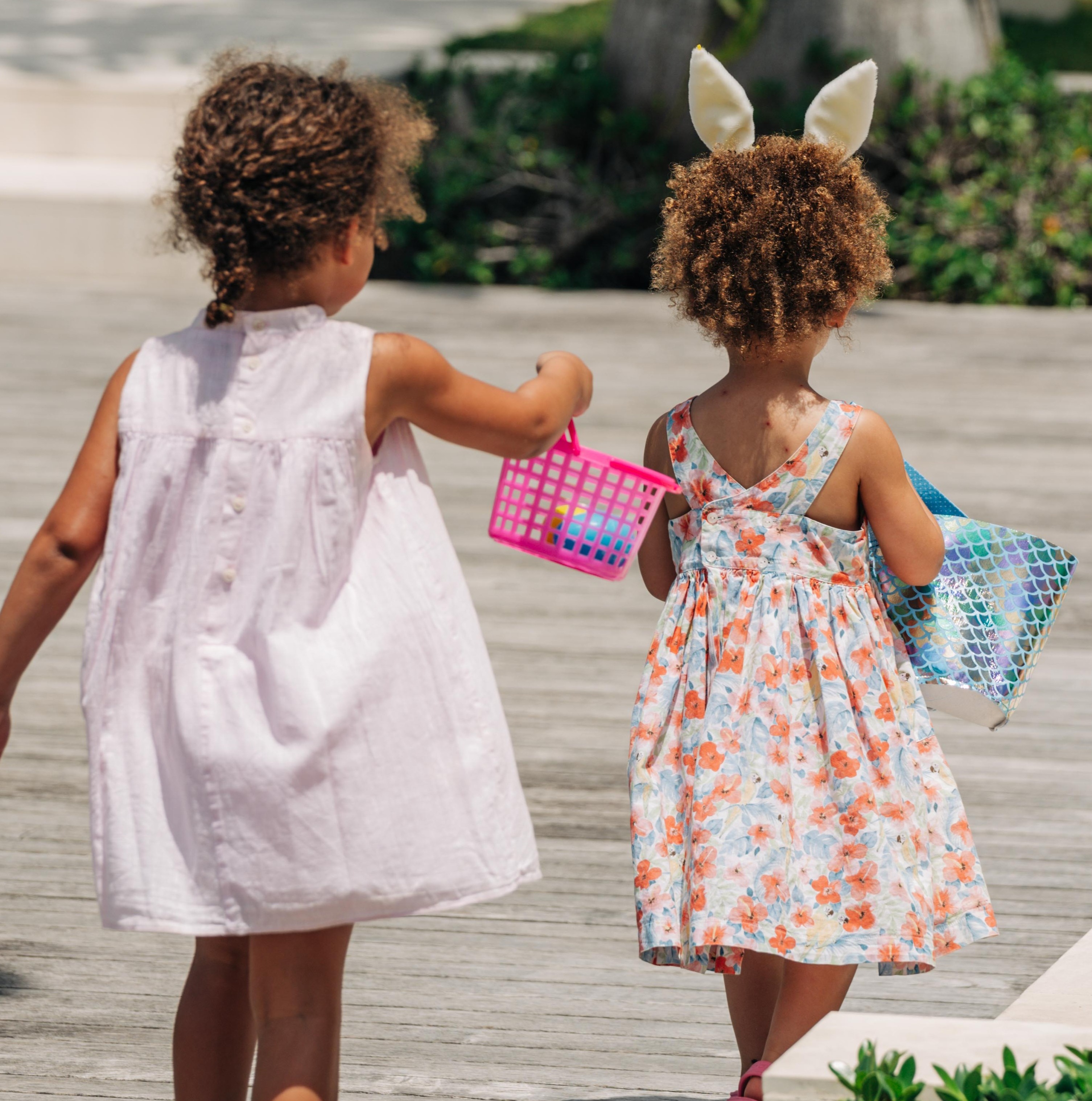 two girls walking on a wooden surface