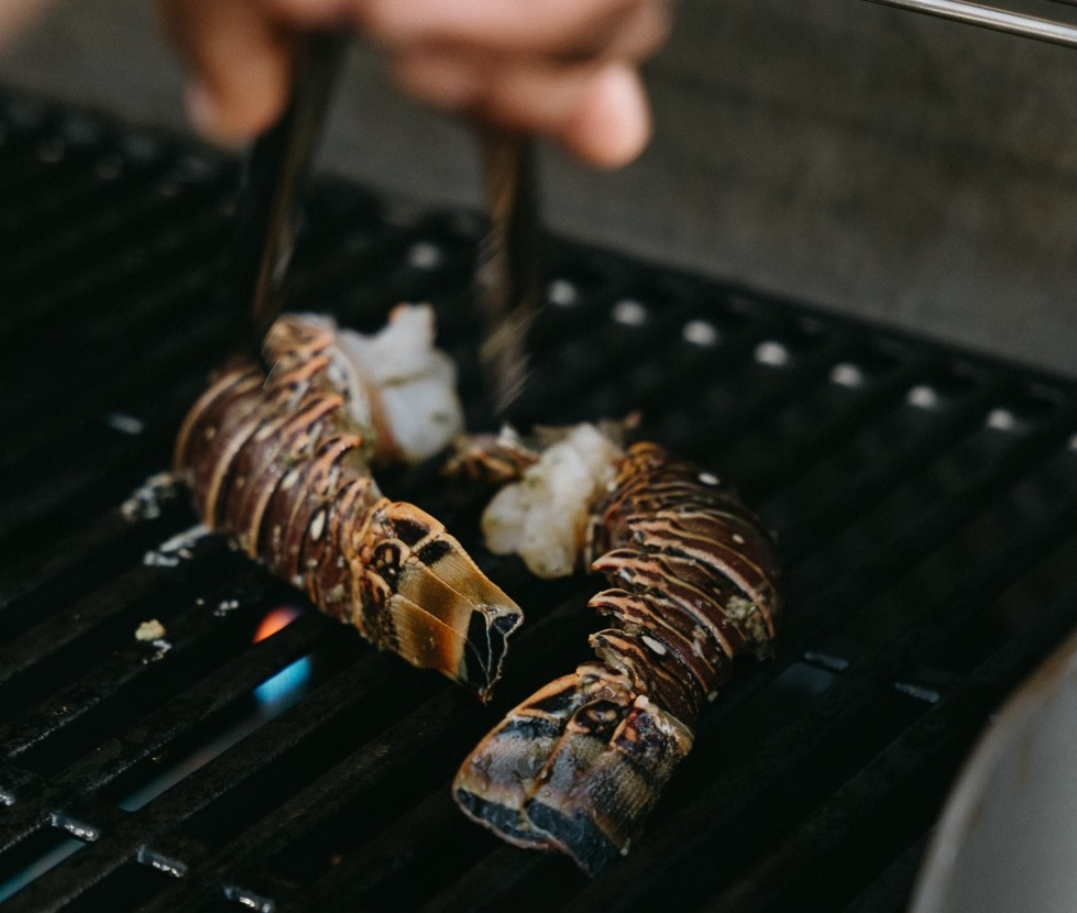 a lobster tail being grilled on a grill