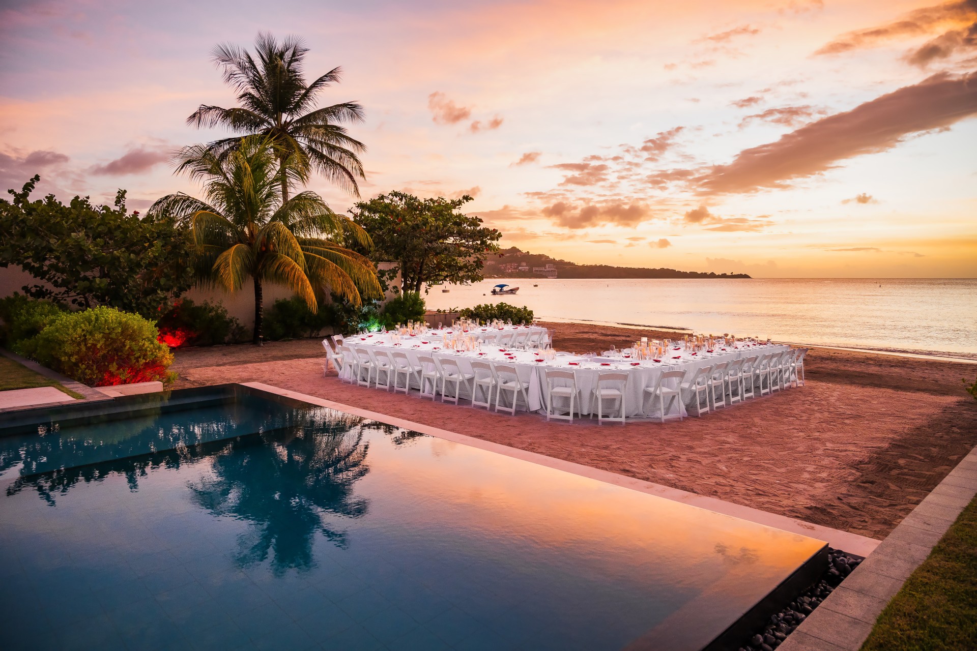 a pool and tables set up on a beach