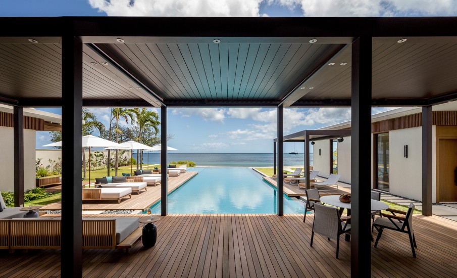 A wooden deck with lounge chairs around a private pool at Silversands Grand Anse.
