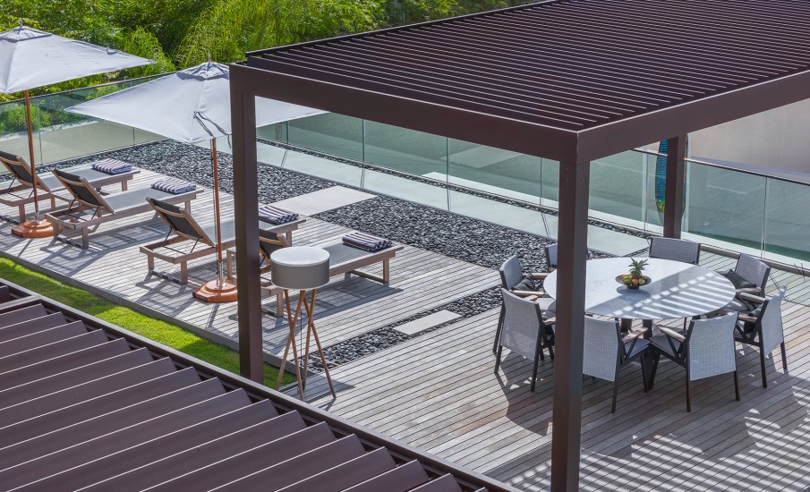 Cabanas and lounge chairs on a rooftop pool deck at a luxury villa in Grenada.