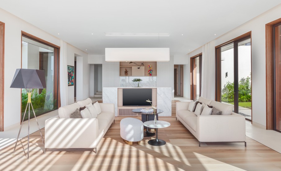 Interior of a living room of a luxury villa at Silversands Grand Anse showing two sofas and a large flat screen television.