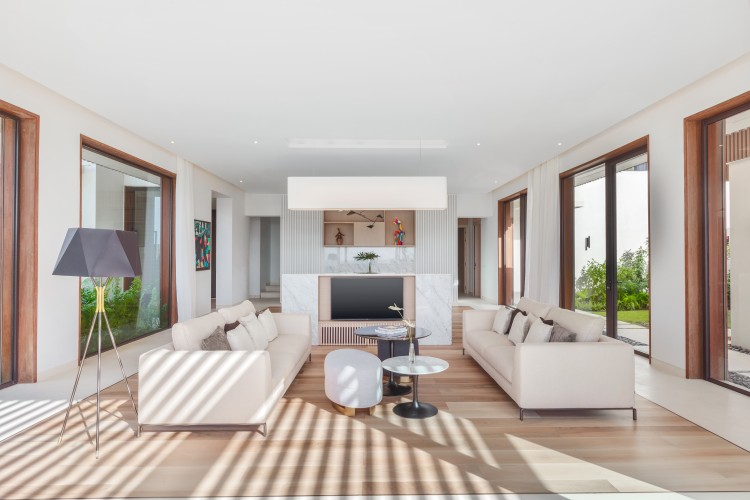a living room with white furniture and a table