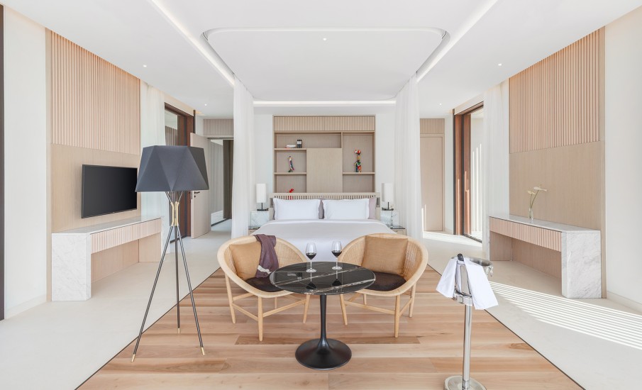 Interior bedroom of a luxury villa in Grand Anse showing a pair of wine glass on a table in front of a bed.