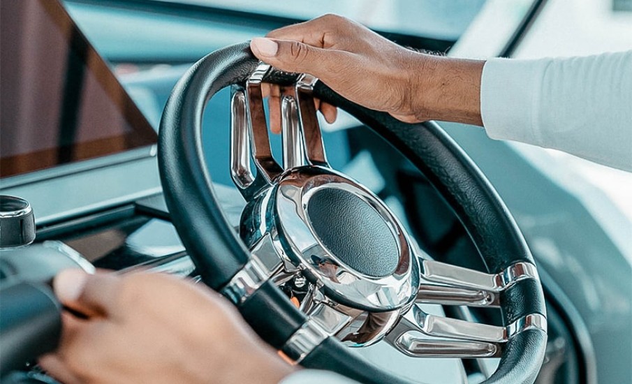 A close-up of a leahet and chrome steering wheel being held by your personal driver at Silversands Beach House Resort.