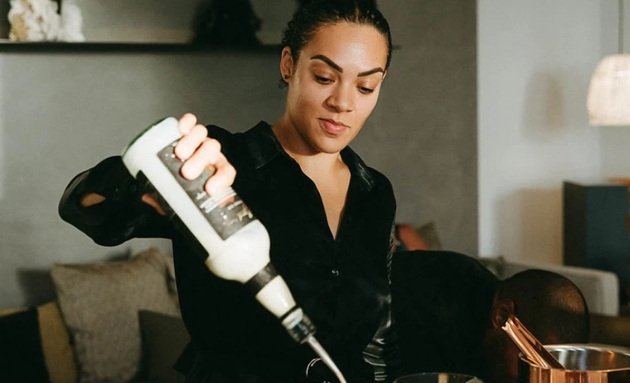 A bartender mixing craft cocktails at a bar in Portici Beach Grenada at Silversands Beach House Resort.											