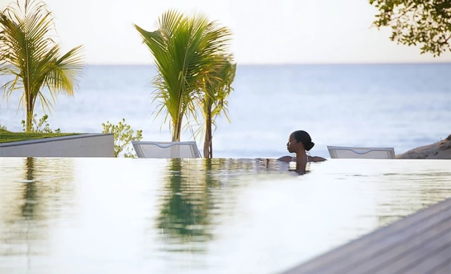 A woman relaxing in an infiniti pool at Silversands Resort in Grenada.											