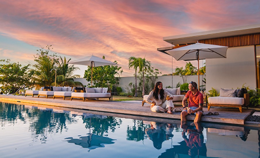 a man and woman sitting by a pool