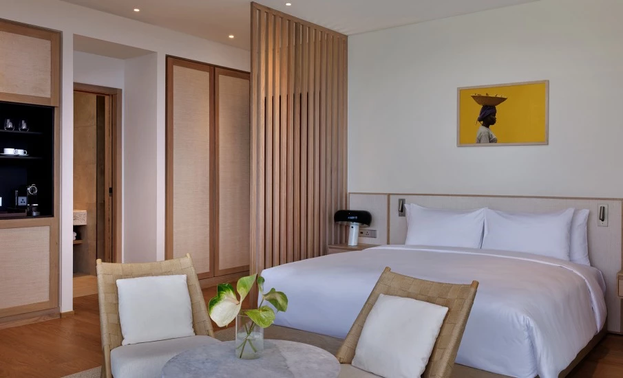 a room with a bed and chairs