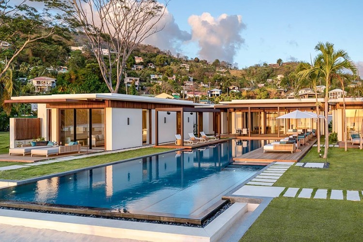 A swimming pool in front of a luxury villa at Silversands Grand Anse resort.