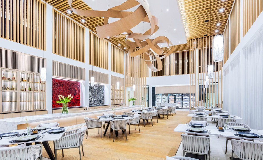 The interior of the dining room at Asiatique Asian restaurant in Grenada showing vaulted ceilings and two rows of tables and chairs.