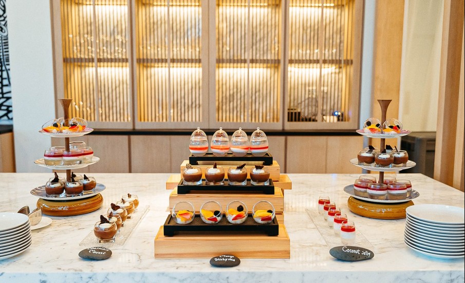 Several desserts on a marble table at a dessert station at Asiatique restaurant in Grand Anse Beach.