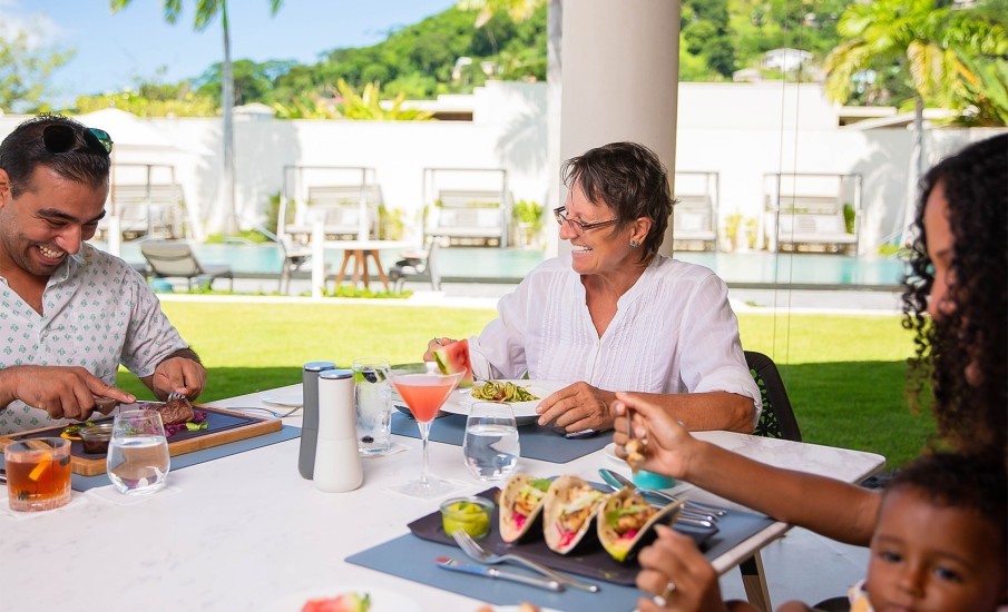 A family enjoy al fresco dining in Grand Anse at Grenadian Grill.