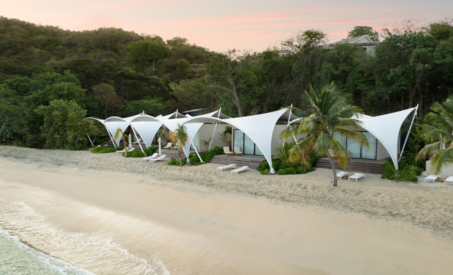 a beach with white tents and palm trees