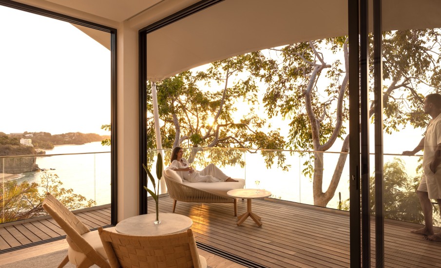 a woman sitting on a chair outside of a glass door