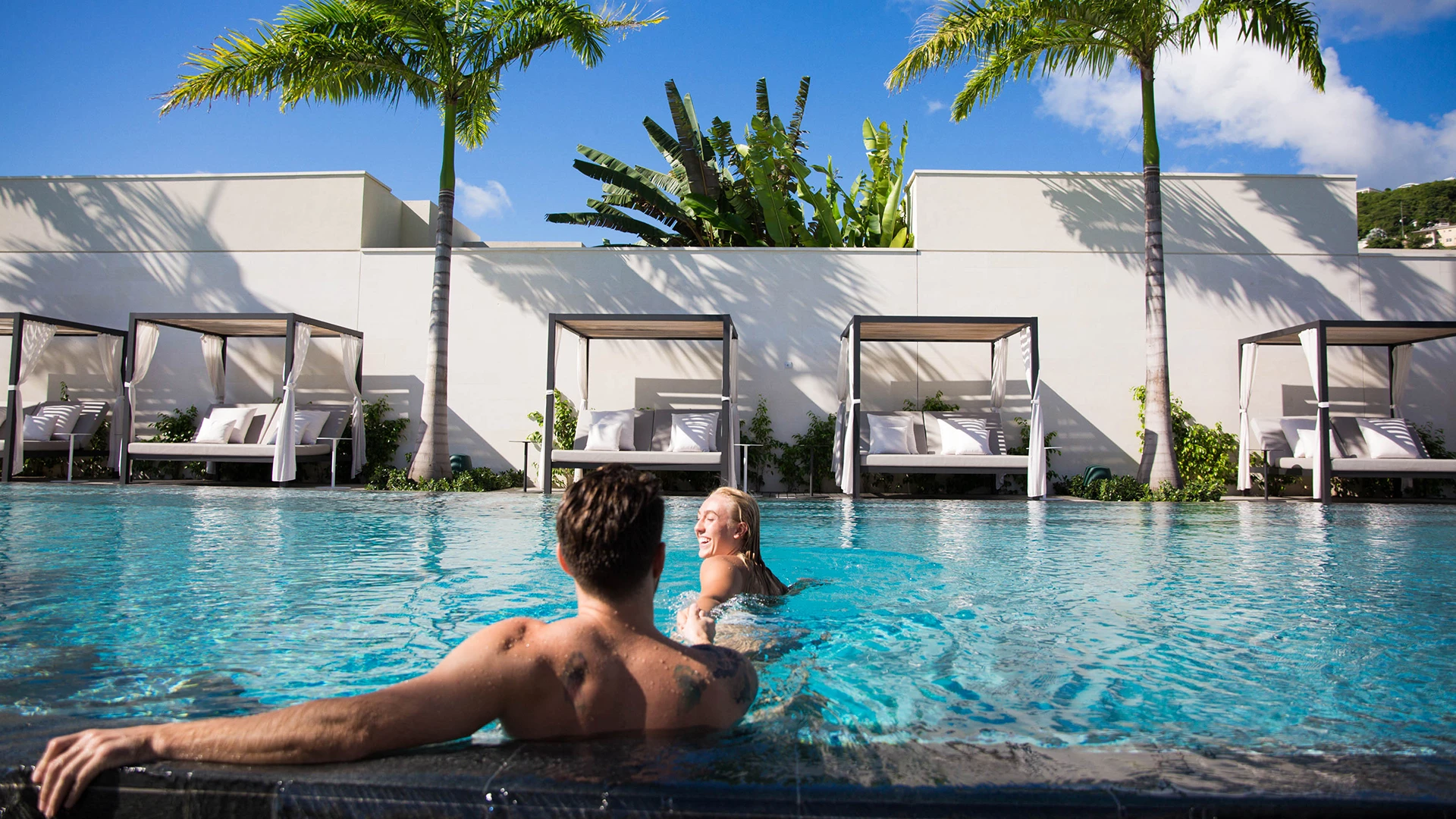 a man and woman sitting in a pool