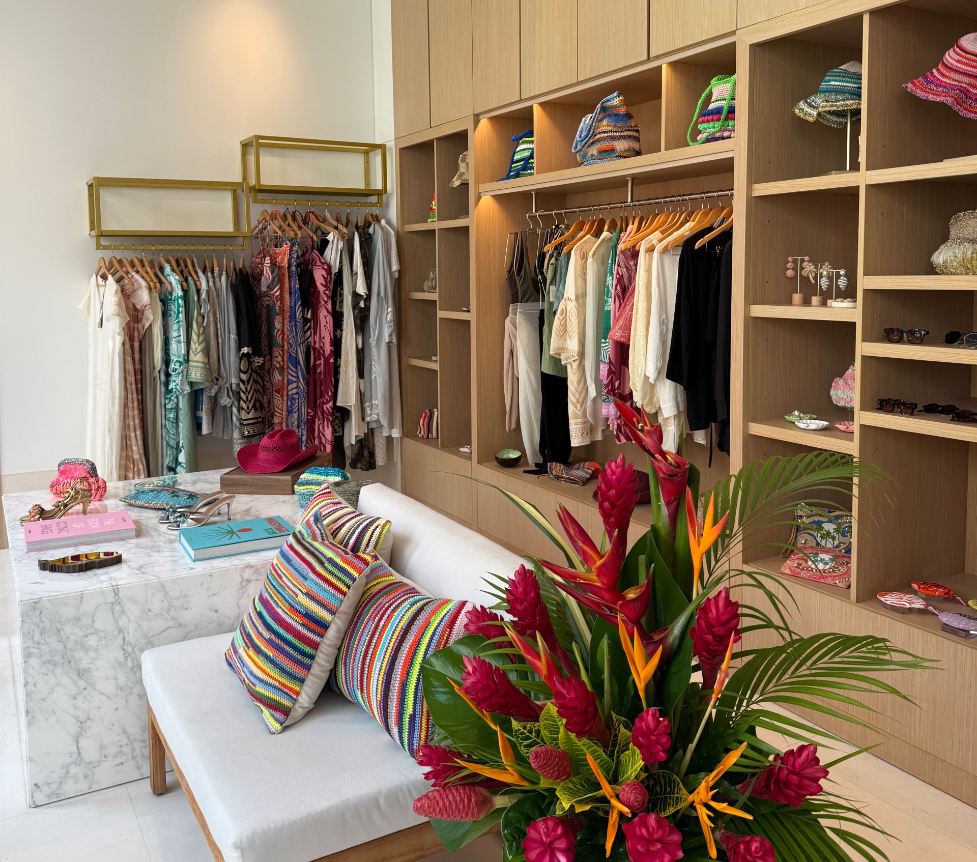 a room with a couch and shelves with clothes and a table