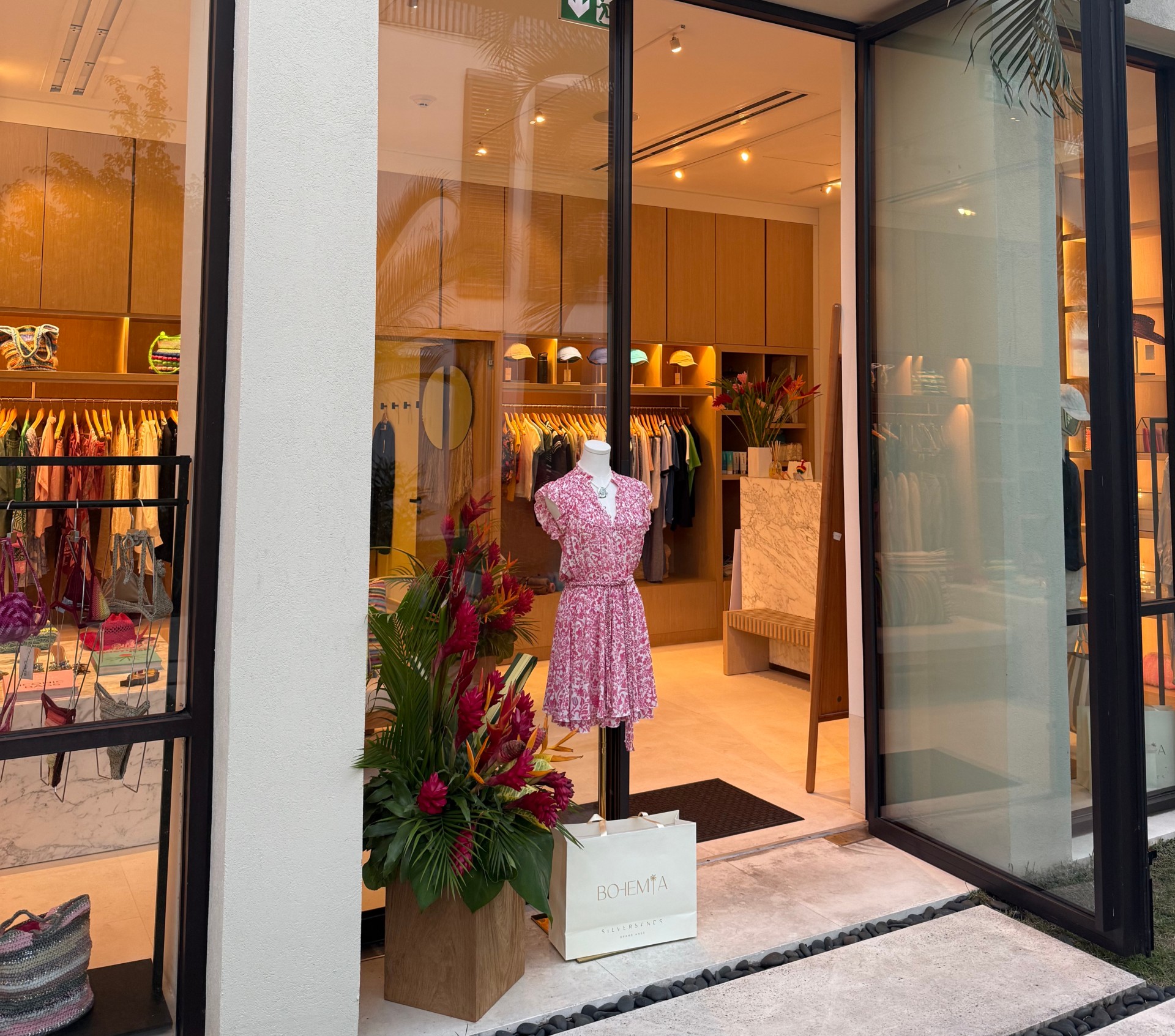 a store front with a mannequin in a pink dress