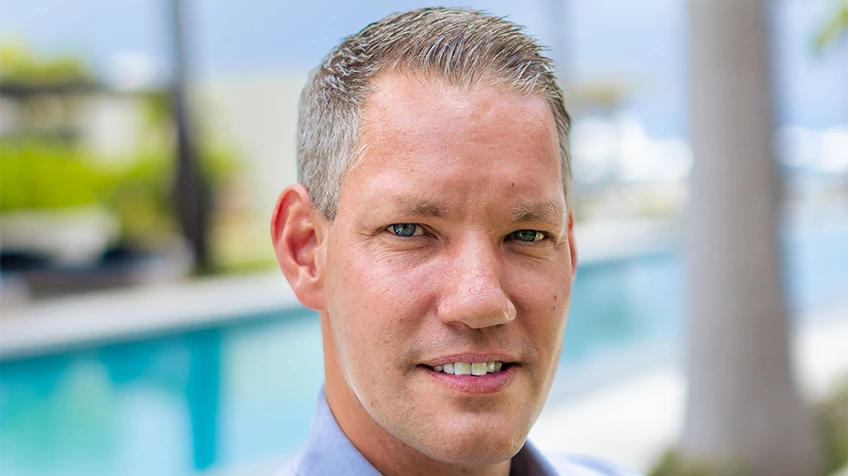 a man with short hair wearing a blue shirt