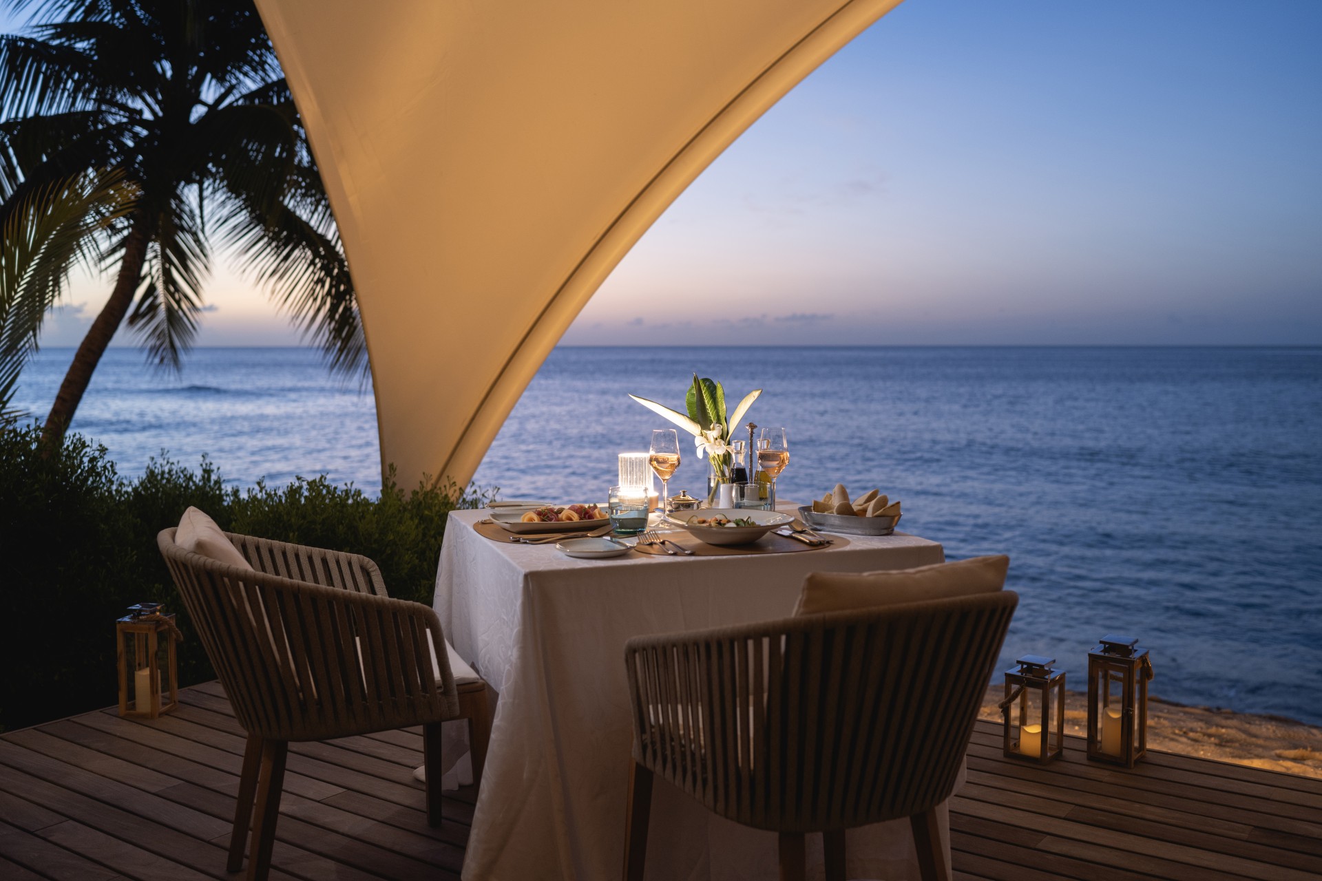 a table with food and drinks on it by the ocean