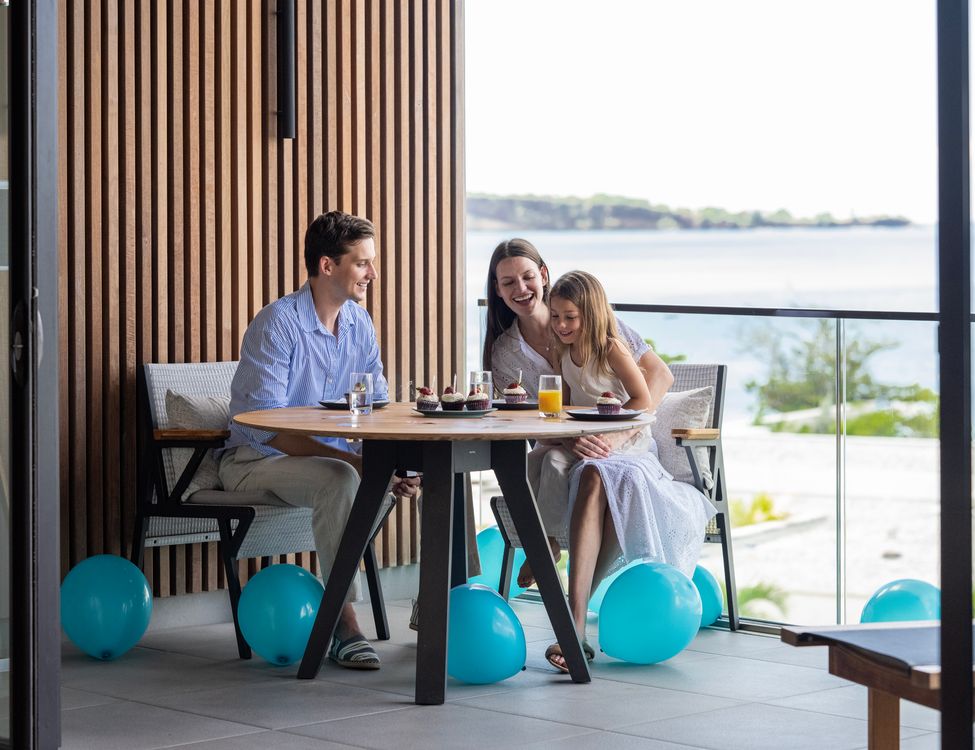 a group of people sitting at a table with balloons