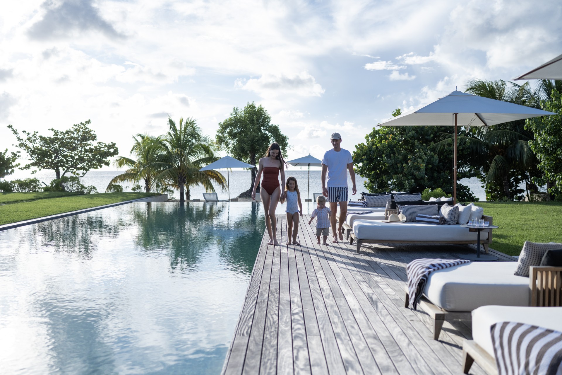 a family walking on a deck near a pool