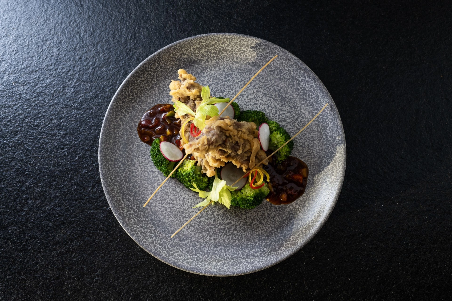 a plate of food on a black surface